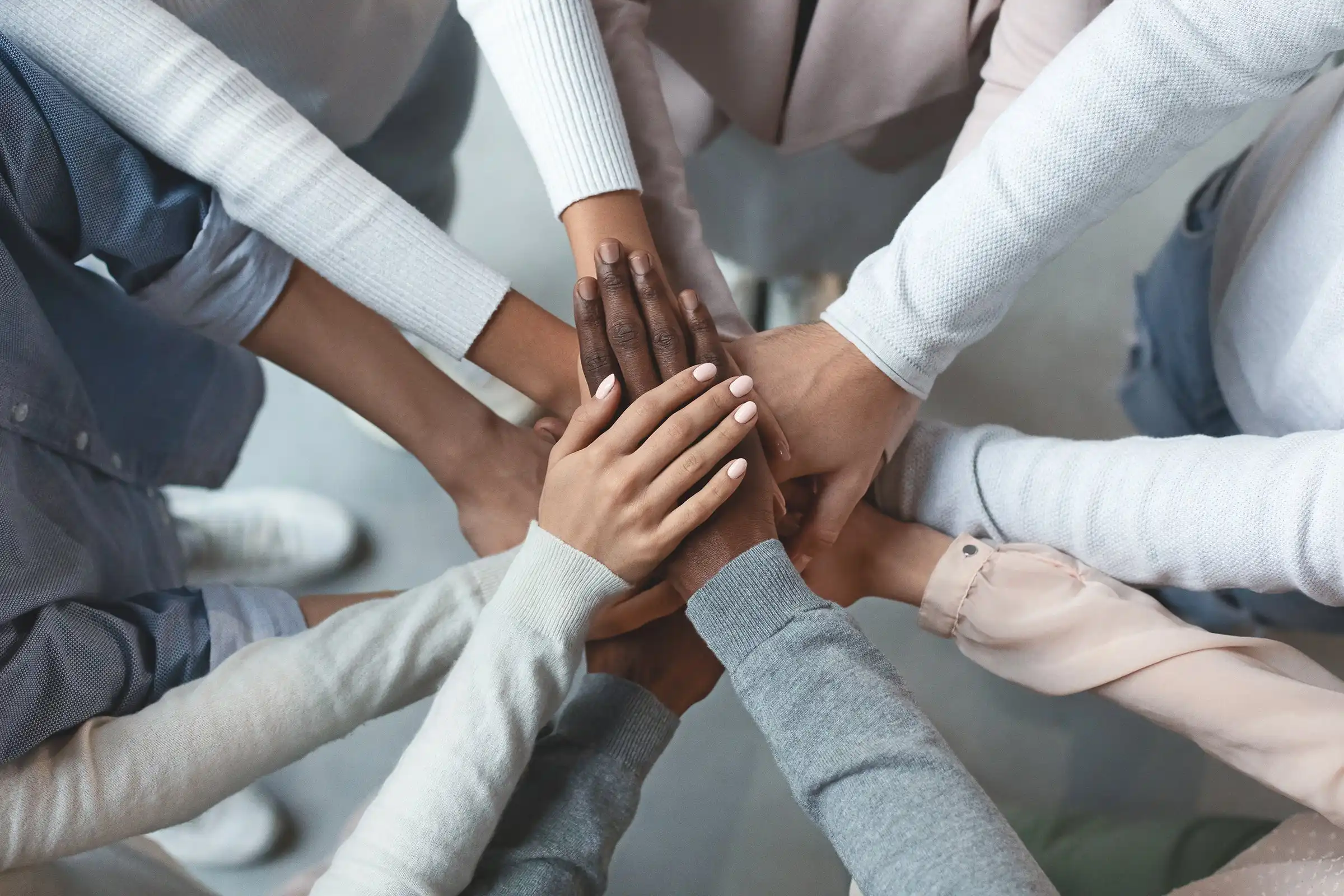 business_team_puts_all_hands_in_for_a_huddle_for_unity_teamwork_team_spirit_trust_diversity_inclusion_by_prostock-studio_gettyimages-1201215883_2400x1600-100859605-orig